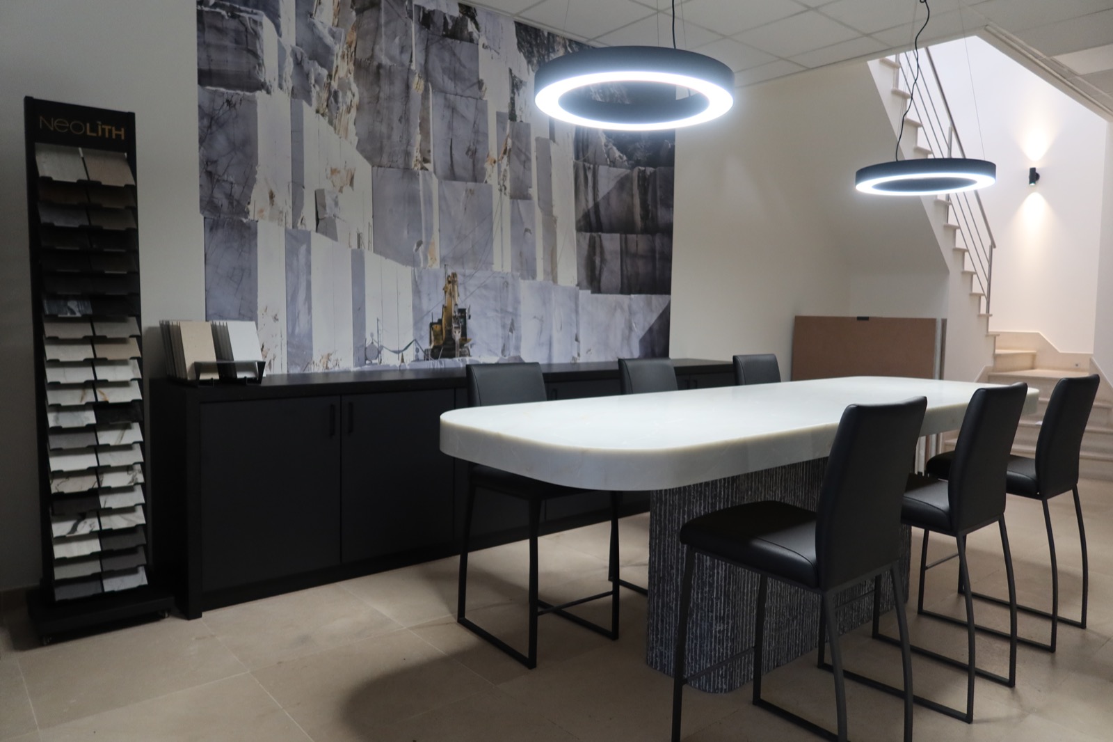 Showroom met een natuurstenen tafel, stalen van werkbladen en een wand met een groevefoto