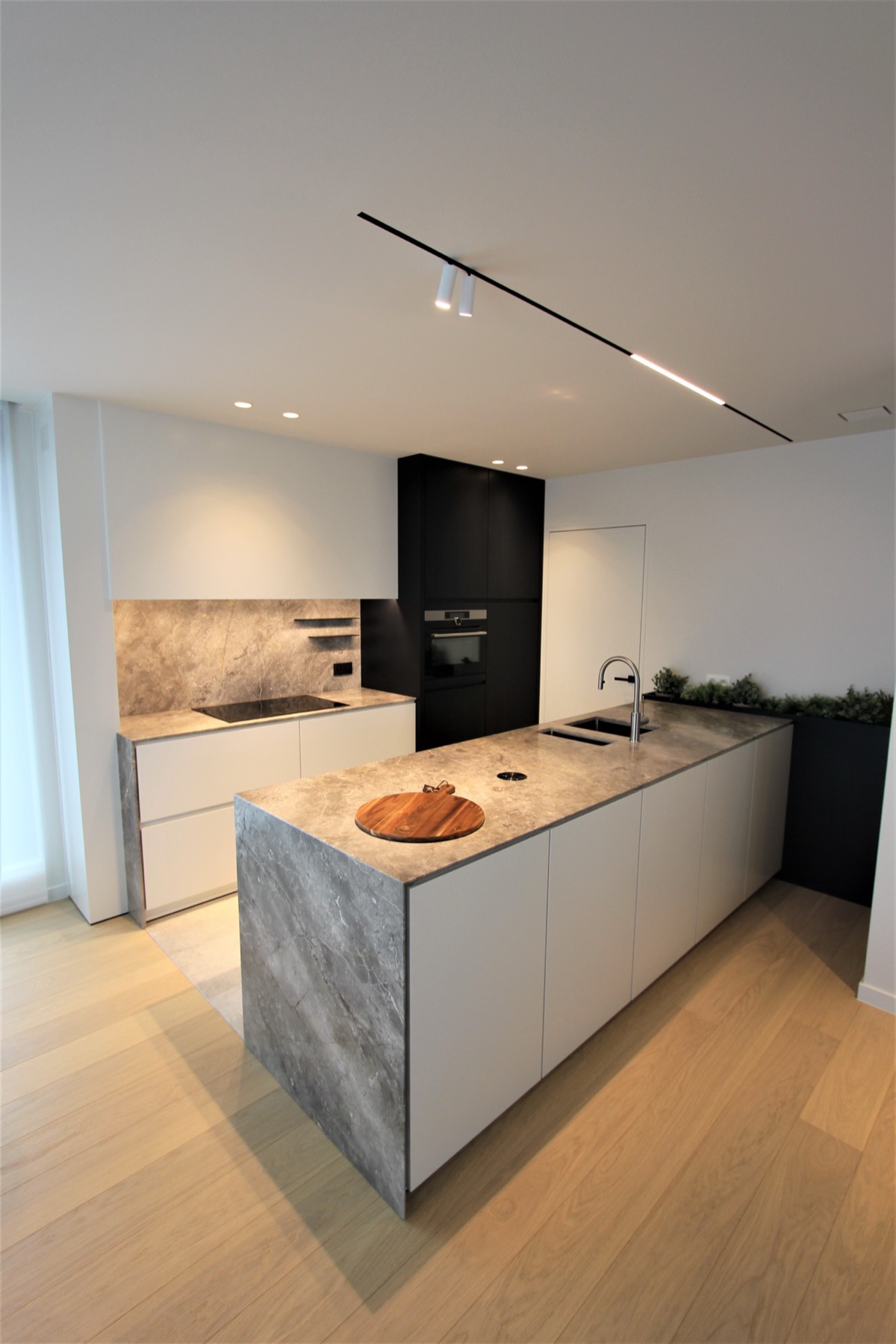Witte keuken met een eiland in grijze natuursteen